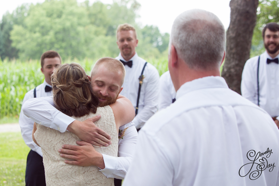 Mom hugging groom during at wedding ceremony