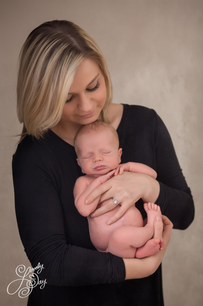 Mom holding newborn baby In Buffalo Portrait Studio