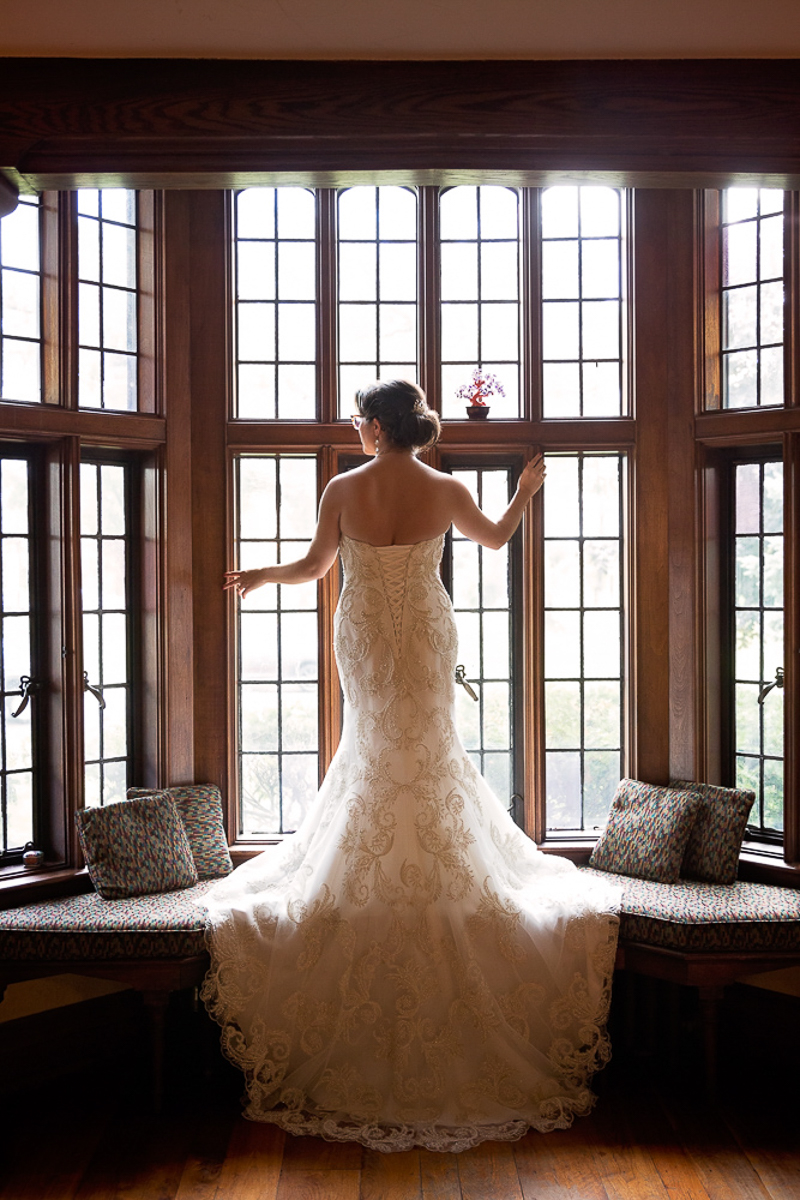 Bride standing in front of large windows.